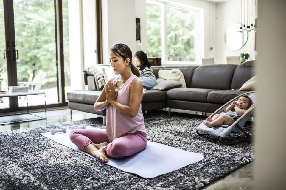 Mother doing yoga at home surrounded by children